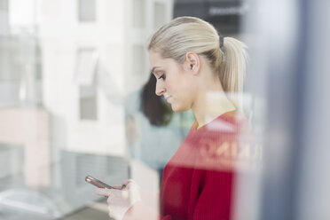 Young female office worker looking at smartphone - ISF03150