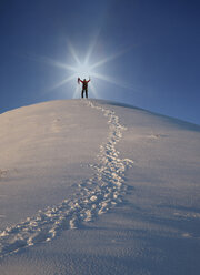 Mountain climber at top of snow capped mountain, arms raised, celebrating, Zermatt, Valais, Switzerland, Europe - ISF03166