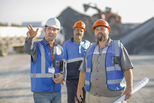 Three quarry workers in discussion, at quarry site - ISF03184