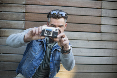 Portrait of mid adult man, taking photograph, using camera - ISF03252