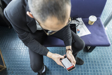 Businessman on passenger ferry looking at smartphone - ISF03258