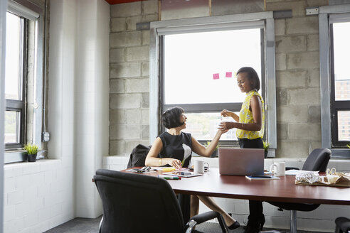 Two women working together in meeting room, brainstorming - ISF03271