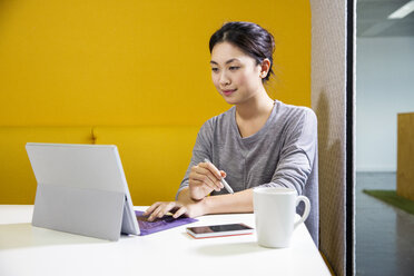 Weibliche Digitaldesignerin am Schreibtisch mit Laptop - ISF03402