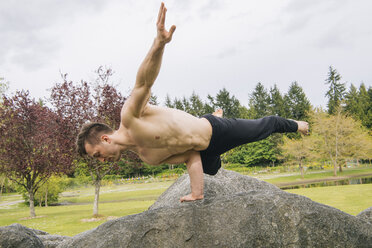 Mann balanciert mit einer Hand auf einem Felsen, Seattle, Washington, Vereinigte Staaten, Nordamerika - ISF03537