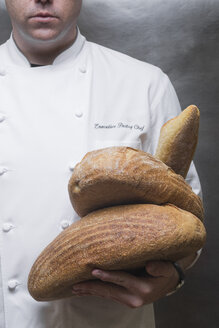 Ausgeschnittenes Porträt eines Konditors mit Broten in der Küche - ISF03559