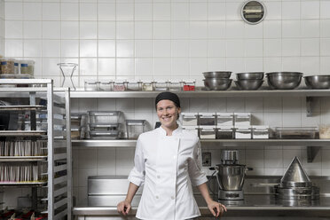 Portrait of chef in commercial kitchen looking at camera smiling - ISF03562