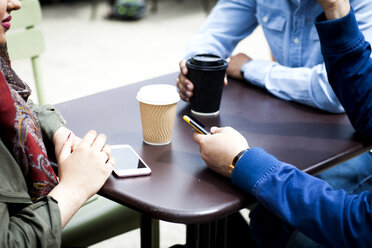 Ausschnitt von Freunden mit Smartphone beim gemeinsamen Kaffeetrinken - ISF03575