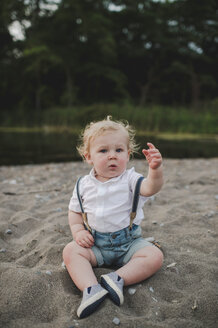 Porträt eines männlichen Kleinkindes am Sandstrand sitzend, Ontariosee, Kanada - ISF03623