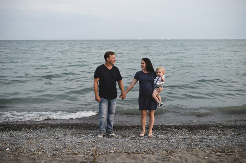 Schwangere Frau am Strand mit männlichem Kleinkind, Ontariosee, Kanada, lizenzfreies Stockfoto