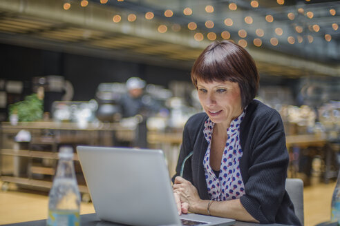 Woman in office using laptop - ISF03649