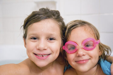 Portrait of sisters in bath looking at camera smiling - ISF03658