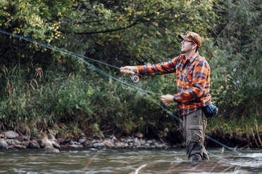 Man wading in river, fishing - ISF03674