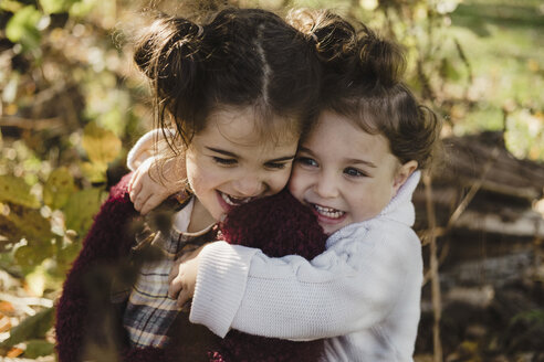 Zwei junge Schwestern, die sich umarmen, in ländlicher Umgebung - ISF03710