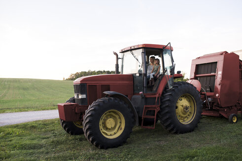 Mutter und Tochter sitzen im Traktor - ISF03773