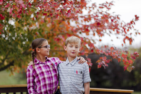 Siblings with arms around each other dressed up as nerds stock photo