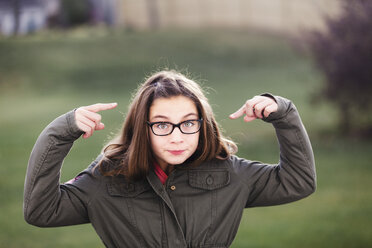 Porträt eines Mädchens mit Brille, die auf ihr Gesicht zeigt - ISF03854
