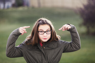 Portrait of girl in spectacles pointing at her face - ISF03854