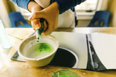 Hands of girl doing science experiment with green liquid - ISF03873