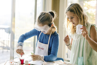 Two girls doing science experiment, with red liquid - ISF03878