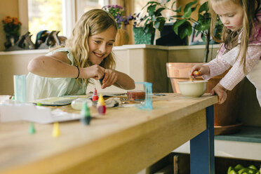 Two girls doing science experiment at table - ISF03880