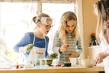 Three surprised girls doing science experiment, staring - ISF03881