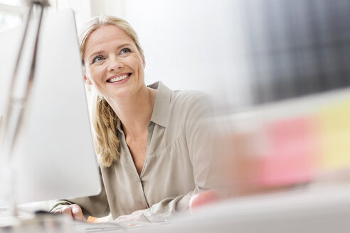 Female designer at desk in creative studio - ISF03926