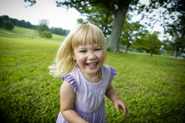 Portrait of blond haired girl running in rural field - ISF03963