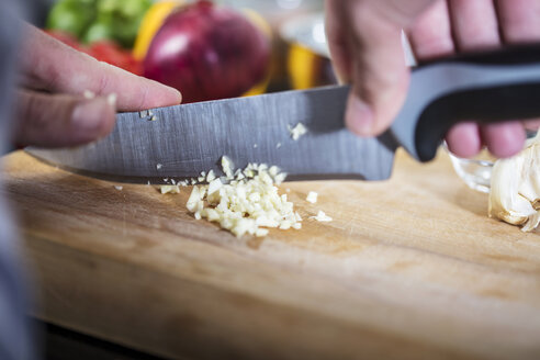 Chef chopping fresh garlic, close-up - ISF03996