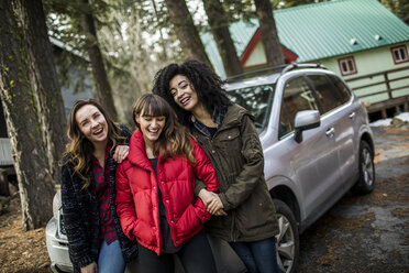 Porträt von drei Freunden, die neben einem Auto stehen und lachen - ISF04013