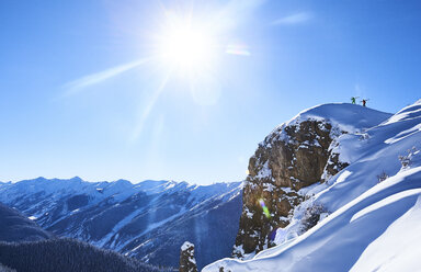 Fernblick auf zwei männliche Skifahrer, die einen schneebedeckten Bergrücken hinaufstapfen, Aspen, Colorado, USA - ISF04025