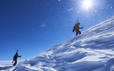 Zwei männliche Skifahrer stapfen einen schneebedeckten Berg hinauf, Aspen, Colorado, USA - ISF04029