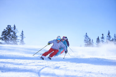 Reihe von männlichen und weiblichen Skifahrern, die eine verschneite Skipiste hinunterfahren, Aspen, Colorado, USA - ISF04034