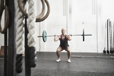 Frau hebt Langhantel im Cross-Training-Fitnessstudio - ISF04052