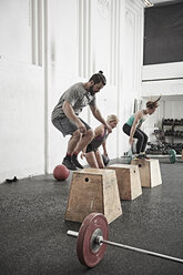 Freunde springen auf die Fitness-Box im Cross-Training-Fitnessstudio - ISF04059