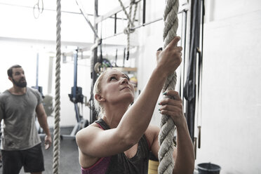 Frau beim Seilklettern in einer Cross-Trainingshalle - ISF04064