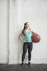 Frau trägt Fitnessball im Cross-Training-Fitnessstudio - ISF04071