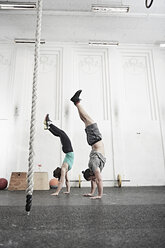 Paar macht Handstand im Cross-Training-Fitnessstudio - ISF04087