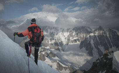 Mountain climber on side of mountain, looking at view, Montblanc, Languedoc-Roussillon, France, Europe - ISF04099