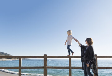 Kleiner Junge geht am Zaun entlang, hält die Hand seiner Mutter, Laguna Beach, Kalifornien, Vereinigte Staaten, Nordamerika - ISF04182
