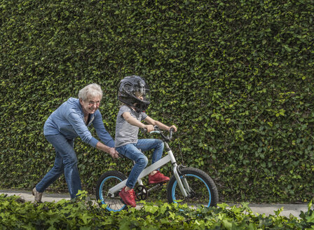 Großmutter schiebt den Enkel auf seinem Fahrrad - ISF04214