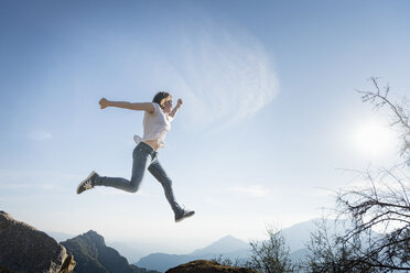 Woman jumping, blue sky in background, Sequoia National Park, California, US - ISF04226