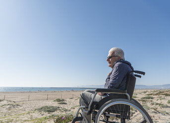 Älterer Mann im Rollstuhl schaut aus den Dünen, Playa del Ray, Kalifornien, USA - ISF04235