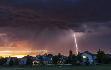 Forked lightning in orange sky over urban area, Aurora, Colorado, United States, North America - ISF04271