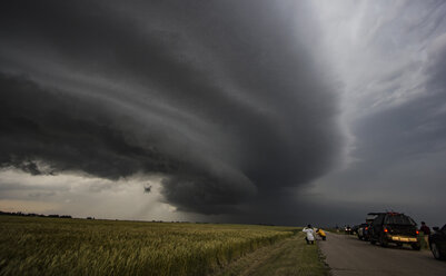 Storm chasers watching arcus cloud and shelf cloud over rural area, Enid, Oklahoma, United States, North America - ISF04274