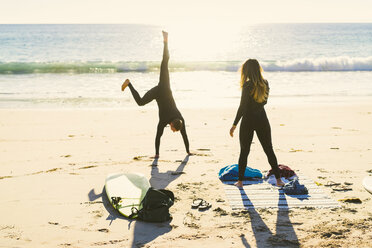 Surfendes Paar, das am Newport Beach, Kalifornien, USA, das Rad schlägt - ISF04312