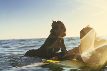 Surfendes Paar lehnt auf Surfbrettern im Meer, Newport Beach, Kalifornien, USA - ISF04317