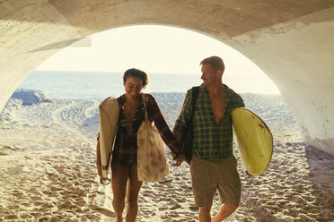 Surfing couple walking in underpass at Newport Beach, California, USA - ISF04325