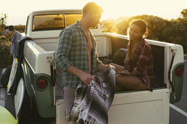Surfing couple in back of pickup truck at sunset at Newport Beach, California, USA - ISF04328
