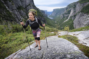Mittlere erwachsene Frau beim Wandern in einem felsigen Tal, Gros Morne National Park, Neufundland, Kanada - ISF04377