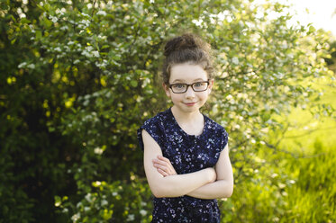 Porträt eines Mädchens mit Brille in einem Feld mit blühenden Bäumen - ISF04386